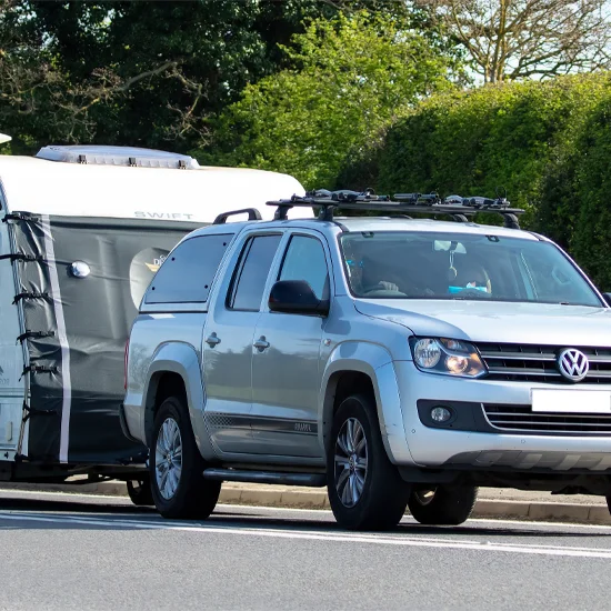 Volkswagen Amarok pick-up towing a caravan on UK road